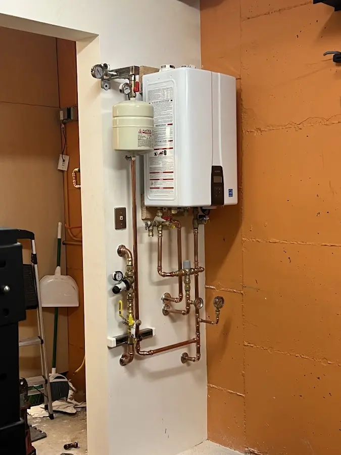 Plumbing technician inspecting water heater connections in Rincon Valley